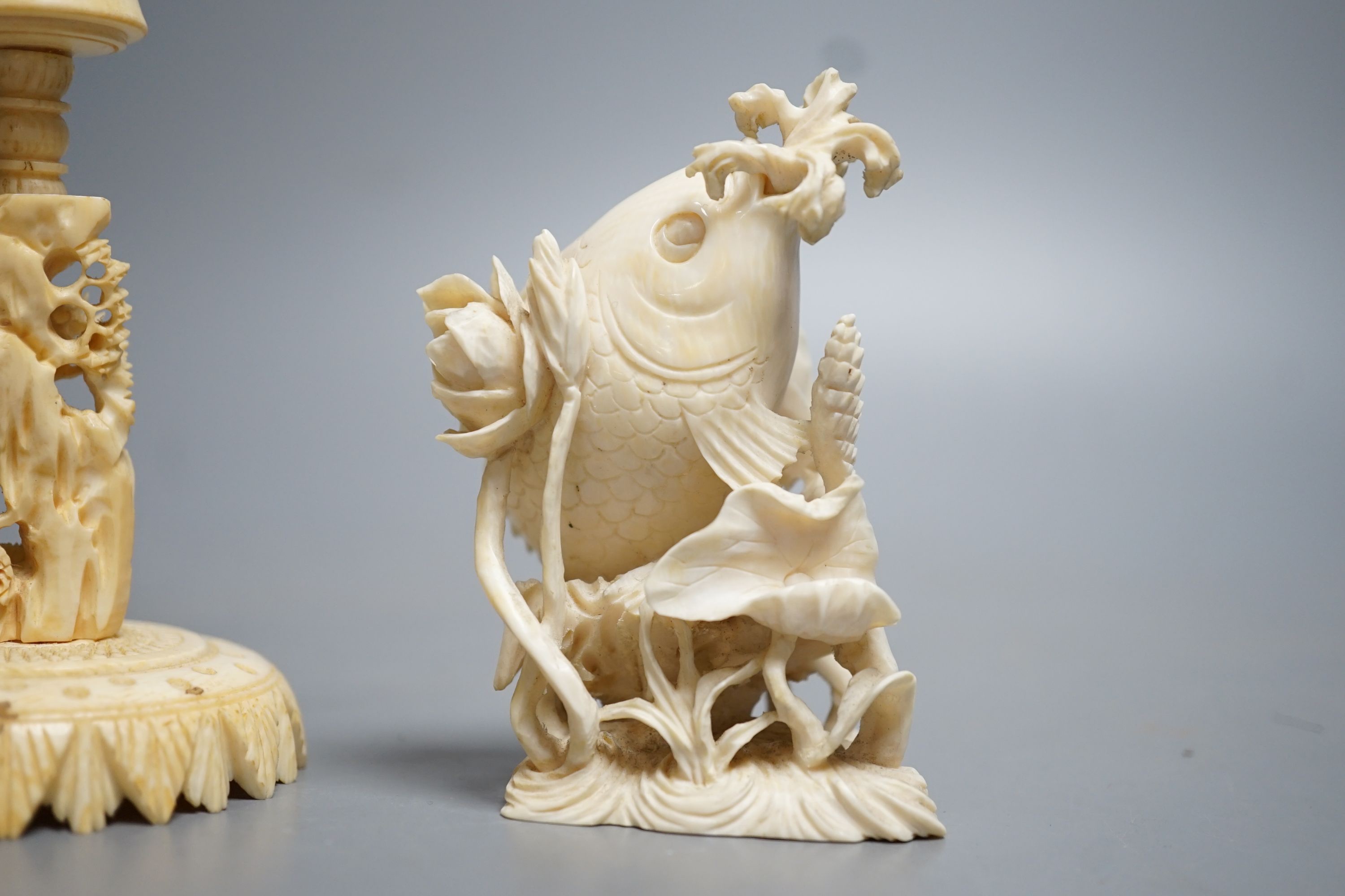 A Chinese ivory concentric puzzle ball and stand, two Chinese ivory snuff bottles and stoppers, modelled as a leaping carp and as cicadas on a nut, early 20th century